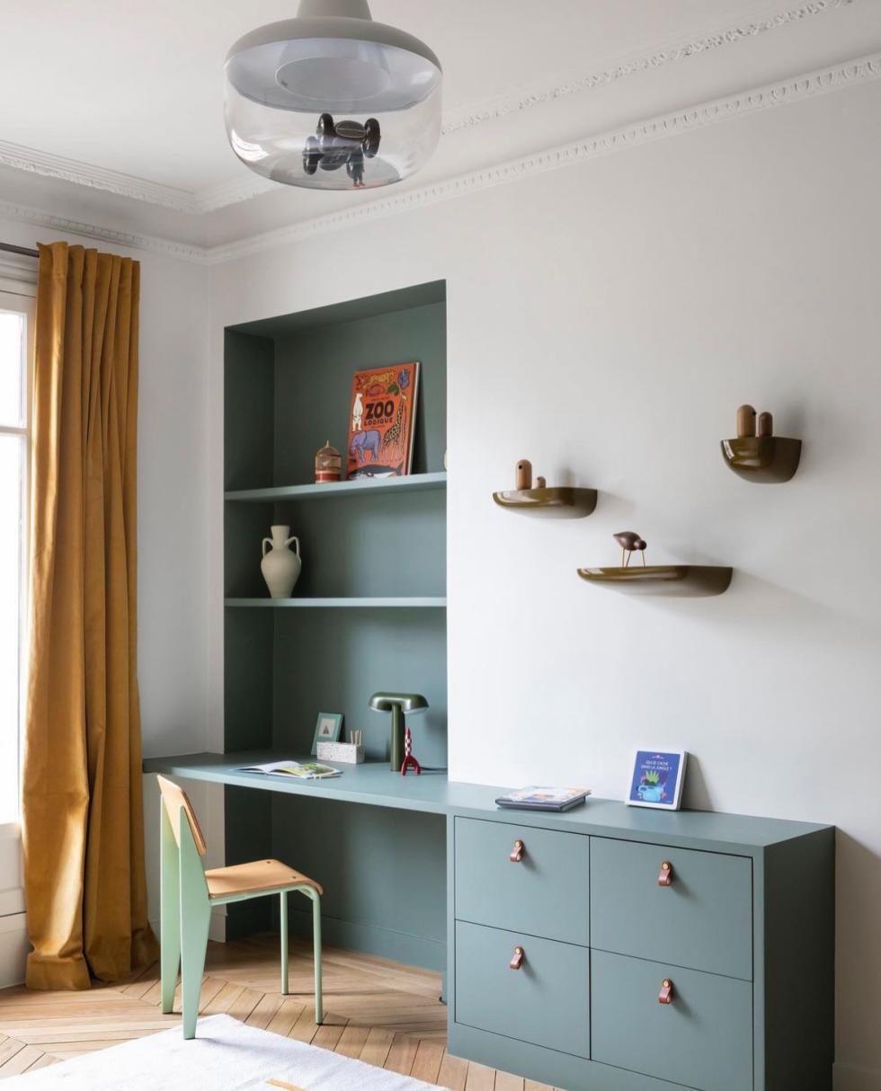 Kinderzimmer mit Schreibtisch und blauen Regalen
