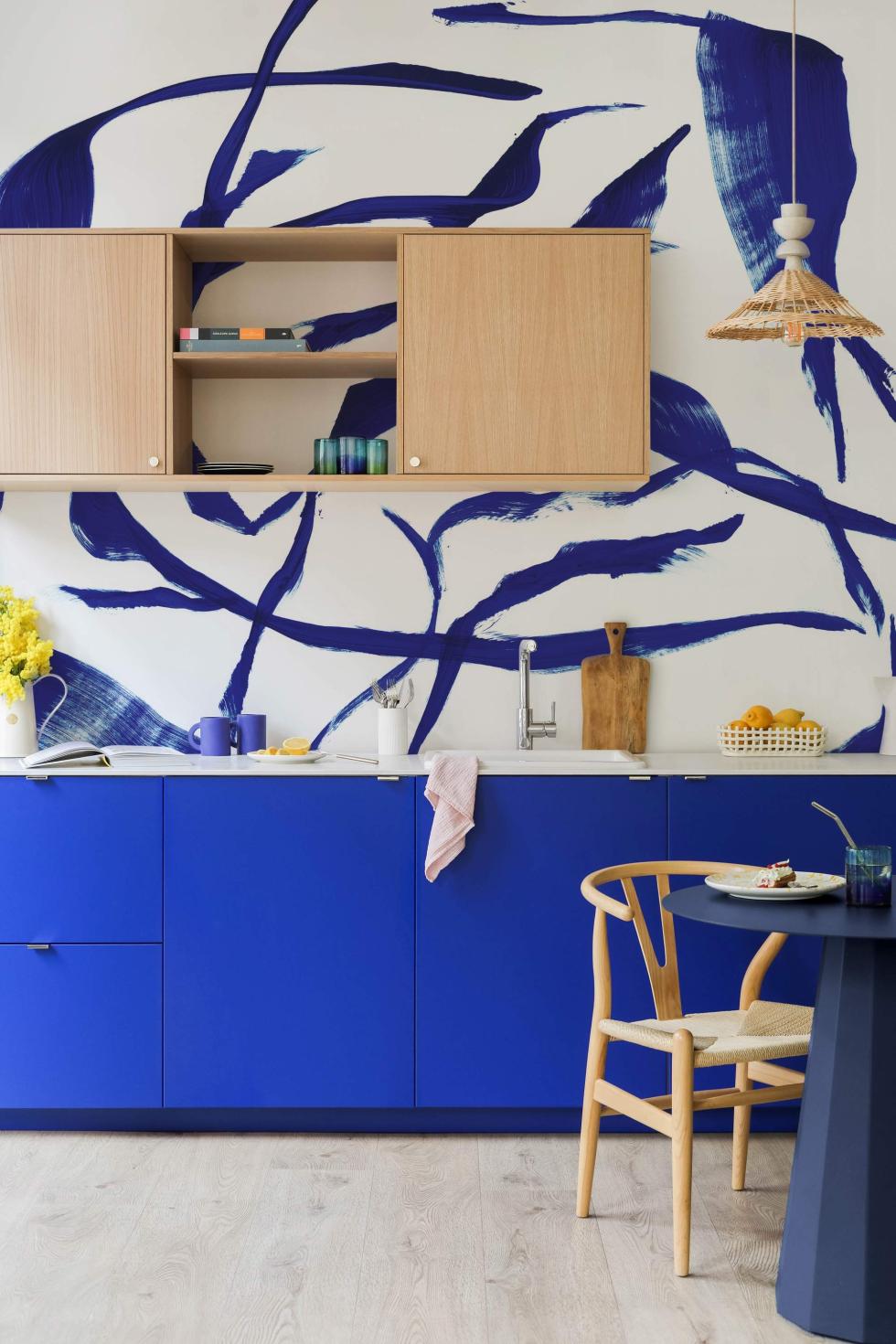 Cuisine Bleu electric et Chêne naturel, avec papier peint bleu.