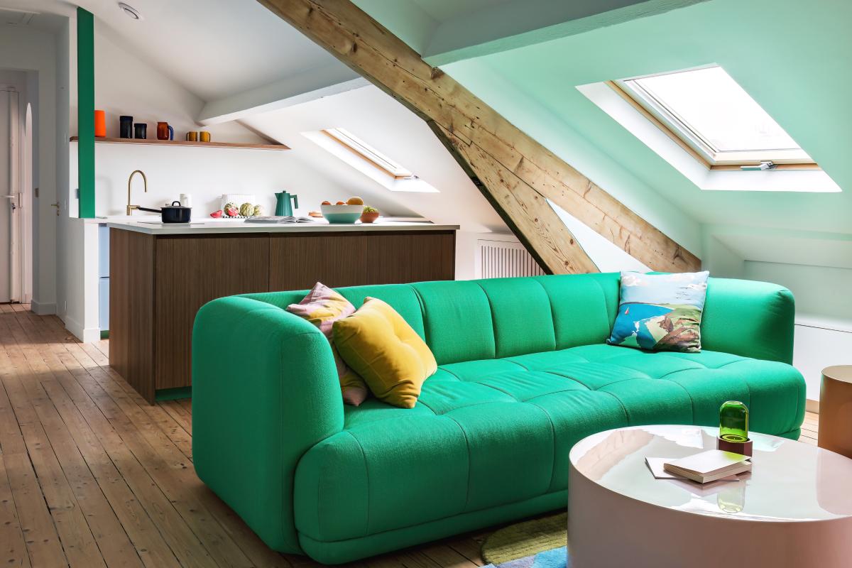 Salon d'un appartement renové par l'architecte Nicolas Payet, cuisine en noyer et mobilier coloré.
